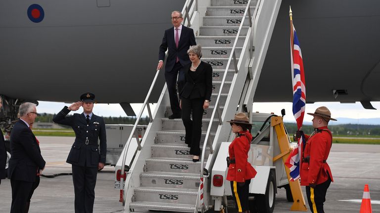 Theresa May and her husband Philip are greeted as they step off the plane in Canada