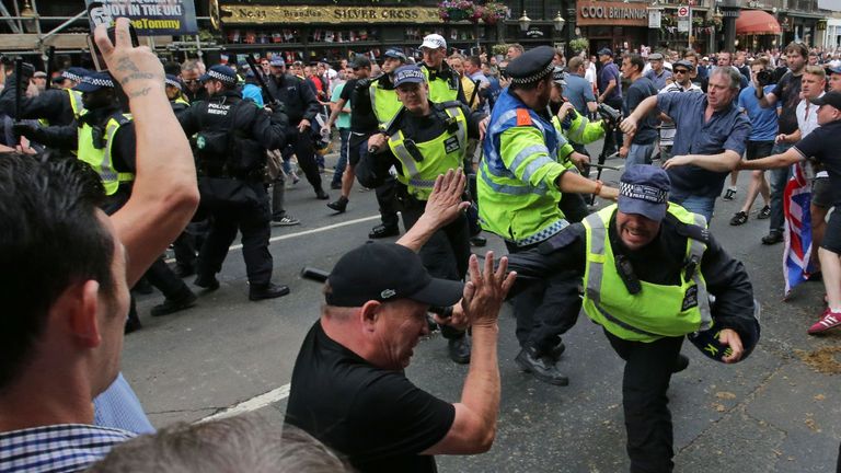 Protesters scuffle with police on Whitehall during a gathering by supporters of far-right spokesman Tommy Robinson in central London on June 9, 2018, following the jailing of Tommy Robinson for contempt of court. (Photo by Daniel LEAL-OLIVAS / AFP) (Photo credit should read DANIEL LEAL-OLIVAS/AFP/Getty Images)
