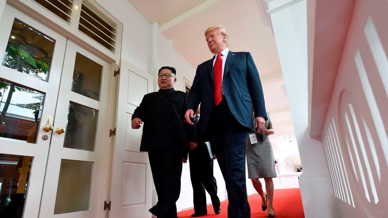 Kim Jong Un and Donald Trump walk together as their one-on-one meeting begins