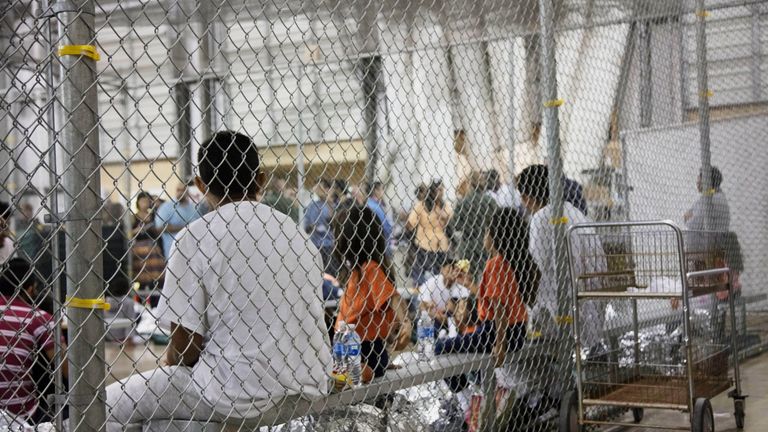 People sit in cages in the facility