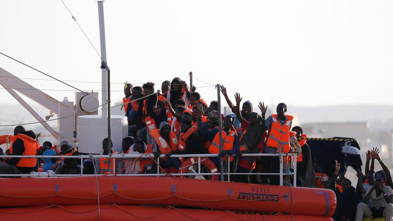 Migrants wave as they approach the harbour in Valletta
