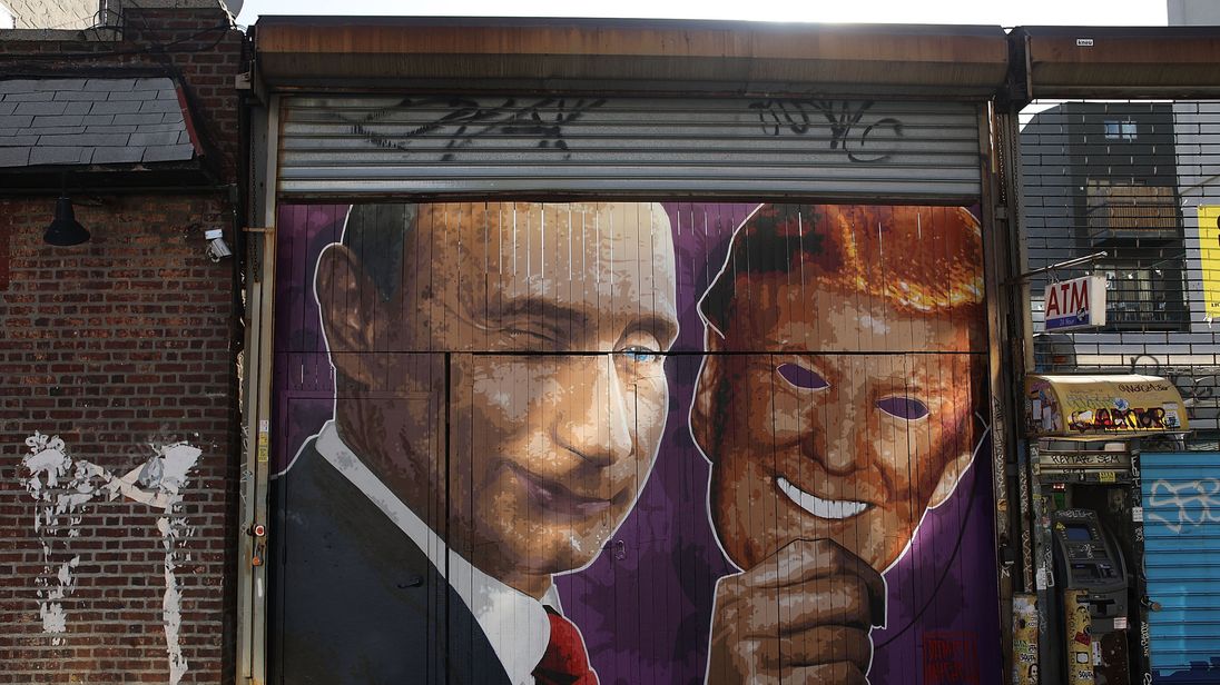 Mural depicting a winking Vladimir Putin taking off his Donald Trump mask on a storefront in Brooklyn New York
