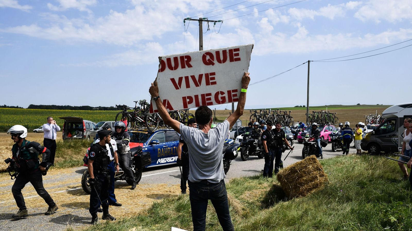 Tour de France briefly halted by protest as riders hit with pepper