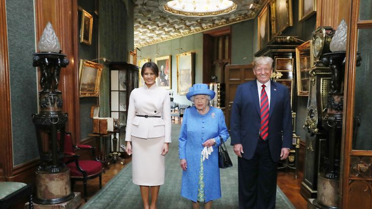   Queen Elizabeth stands with Donald Trump and his wife, Melania, in the hallway during his visit to Windsor Castle 