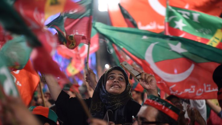Supporters of Pakistani cricket star-turned-politician and head of the Pakistan Tehreek-e-Insaf (PTI) Imran Khan, cheer and wave flags during a rally during the last campaign day, in Lahore, on July 23, 2018