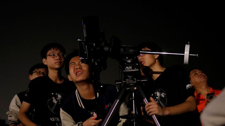   Students in astronomy in Singapore trying to catch a glimpse of the moon at Marina South Pier 