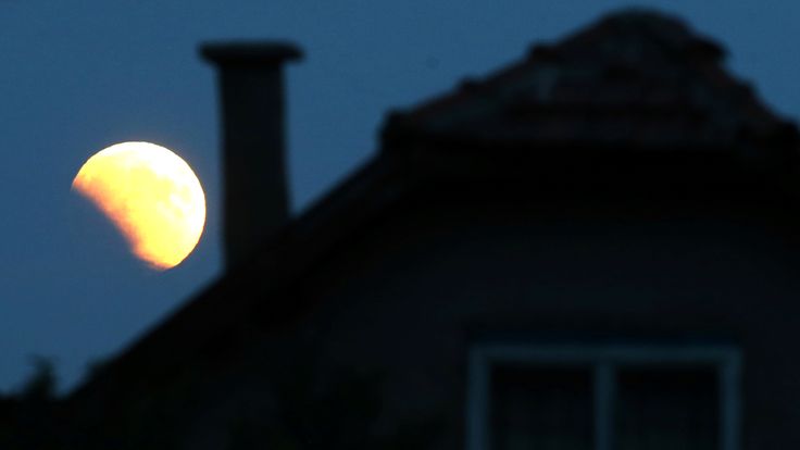   The moon rises behind a house in Zenica, Bosnia and Herzegovina
