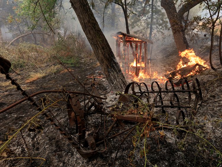 A wooden structure burns on the south edge of the Carr Fire near Igo, California