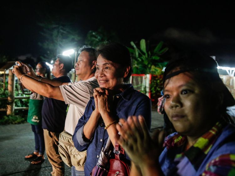 Onlookers watch and cheer as ambulances deliver boys rescued from a cave in northern Thailand to hospital in Chiang Rai after they were transported by helicopters on July 8, 2018 in Chiangrai