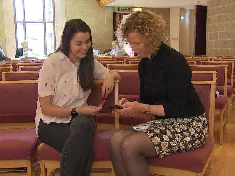 Rev Margaret Cave takes a contactless payment from a church member
