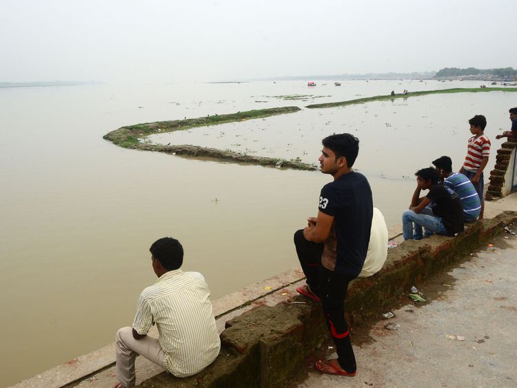 People look at the flooded banks of the Ganges river 