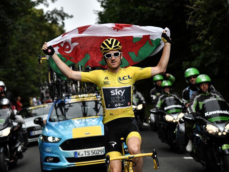 Great Britain's Geraint Thomas holds the Welsh flag
