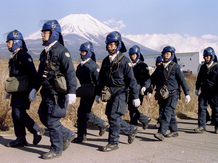 A police squad leave a Aum Shinri Kyo (Supreme Truth Sect) compound after finishing their shift in the small village of Kamikuishiki at the foot of Mount Fuji in this March 28, 1995 file photo