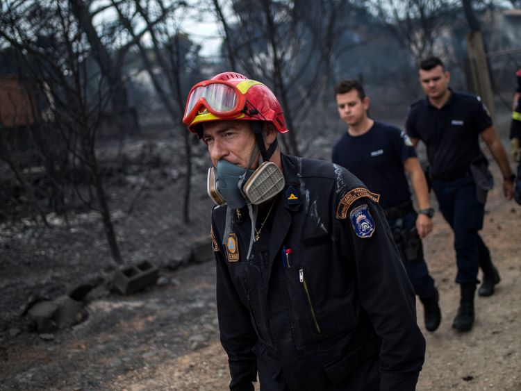 Rescuers arrive at the area where dead bodies were found following a wildfire at the village of Mati, near Athens, on July 24, 2018