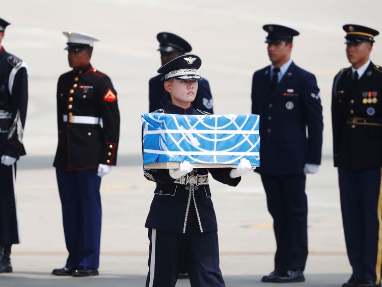 The remains were carried in boxes covered in blue United Nations flags