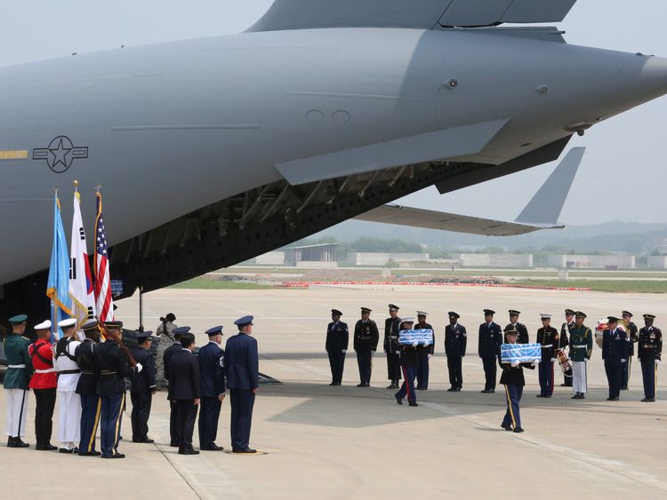 Guards carry boxes containing the remains upon the military plane&#39;s return to South Korea