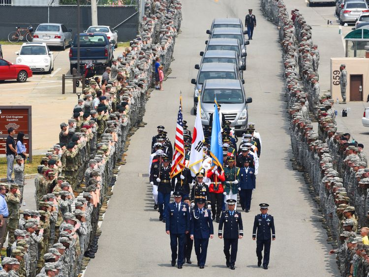 Members of the United Nations Command stand at attention upon the arrival of 55 boxes of soldier remains