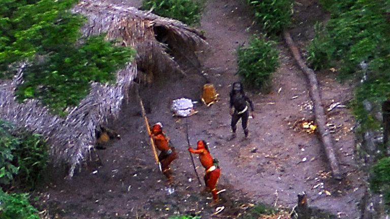 Members of an uncontacted Amazon Basin tribe and their dwellings are seen during a flight over the Brazilian state of Acre