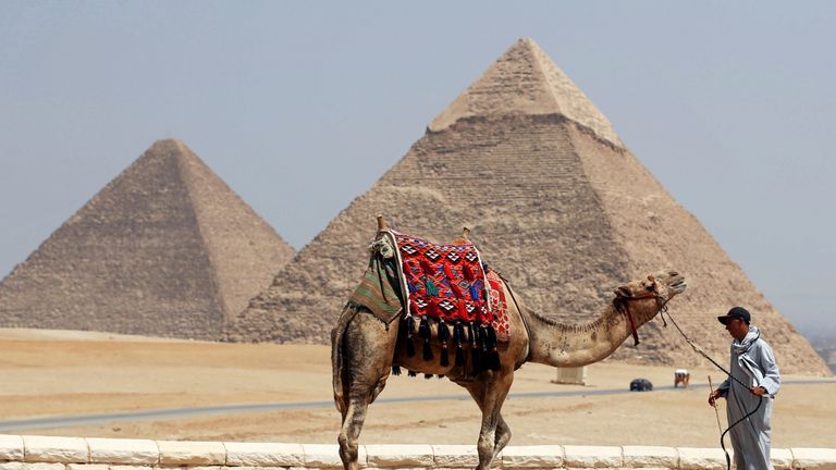 A man waits for tourists to rent his camel in front of the Great Giza pyramids on the outskirts of Cairo, Egypt, August 31, 2016. Picture taken August 31, 2016