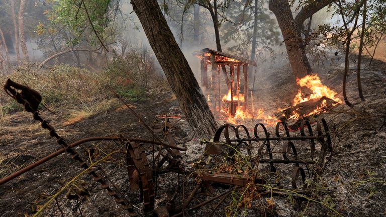A wooden structure burns on the south edge of the Carr fire near Igo, California