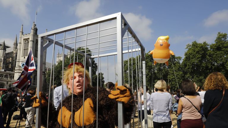 Protesters gather around a giant balloon depicting US President Donald Trump as an orange baby during a demonstration against Trump&#39;s visit to the UK 