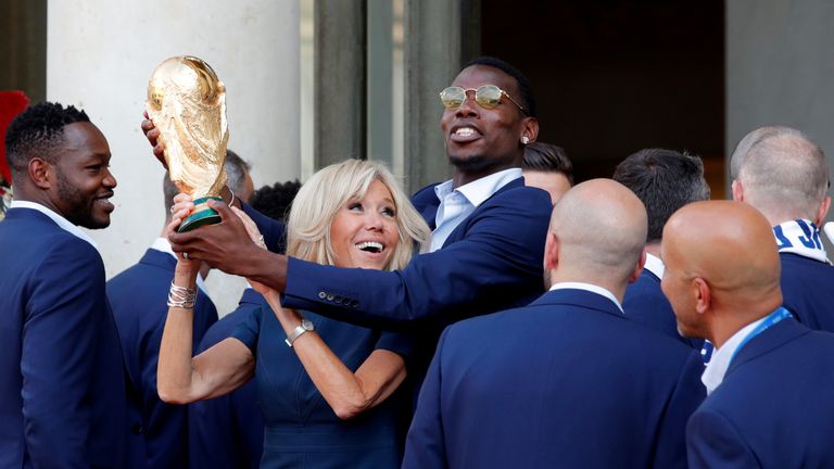 Brigitte Macron and midfielder Paul Pogba hold the trophy