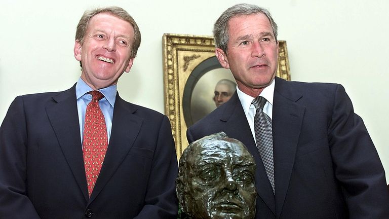 George W. Bush (R) smiles after receiving a bust of Sir Winston Churchill from British Ambassador to the United States Christopher Meyer in the Oval Office of the White House in Washington in 2001
