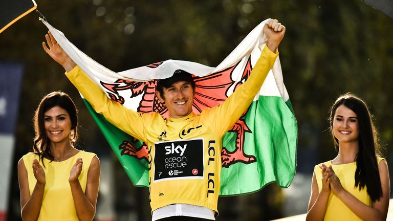 Tour de France 2018 winner Great Britain&#39;s Geraint Thomas holds the Welsh flag as he celebrates his overall leader yellow jersey on the podium