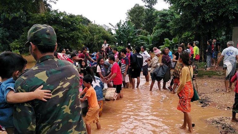 Villagers carry their belongings as they evacuate after the Xepian-Xe Nam Noy hydropower dam collapsed in Laos