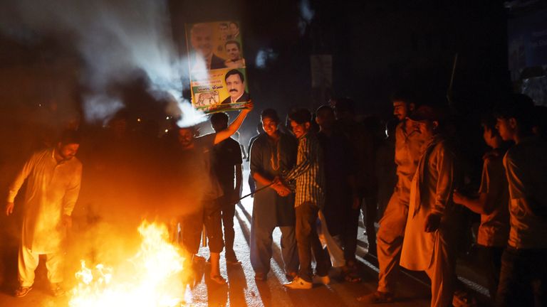 Supporters of former Pakistani Prime Minister Nawaz Sharif burn tyres during a protest ahead of of the arrival of Nawaz from London