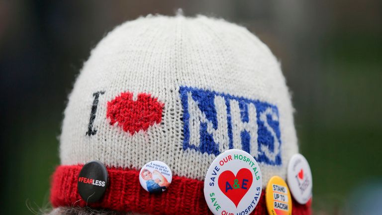 A protester wears badges on her hat as she attends a rally against private companies&#39; involvement in the National Health Service (NHS) and social care services provision and against cuts to NHS funding in central London on March 4, 2017