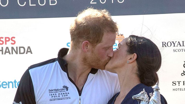 Meghan grabbed a kiss from her husband at the fixture