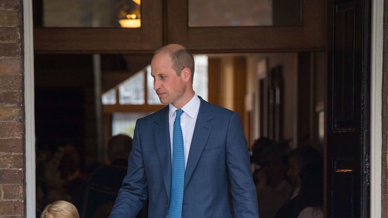 William guides two of his children at the christening of his youngest