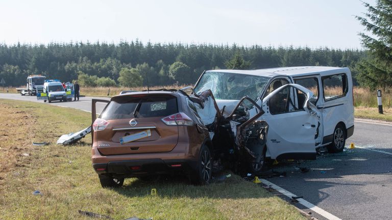 A car is removed from the A96 between Huntly and Keith in Moray where a five people have died and five more were injured after a crash between a minibus and a car.
