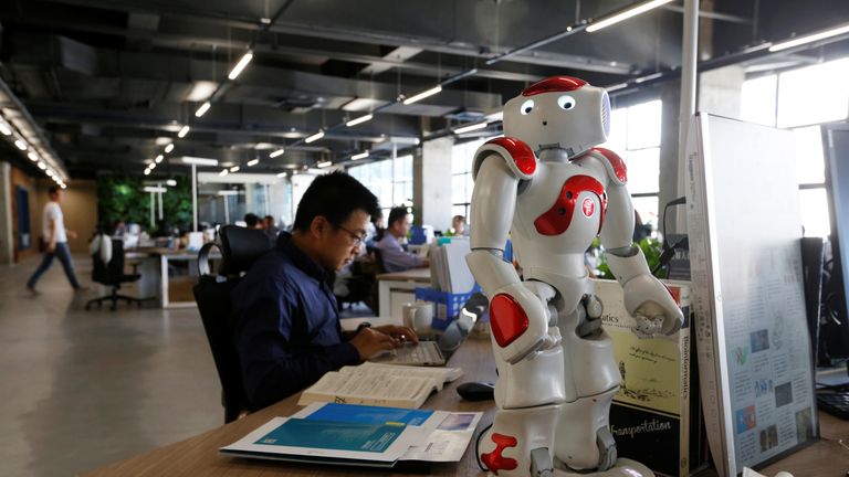 Staff work behind a robot at iCarbonX, a start up company in Shenzhen