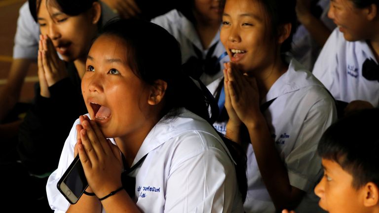 Classmates react after they hear that some of the 12 boys trapped inside the cave have been rescued
