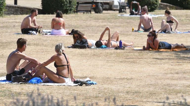 People sunbathe in Haggerston Park, in east London in July