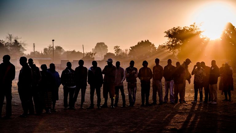 People queued as morning broke in the Mbare suburb of Harare