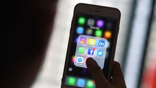 This photo illustration taken on March 22, 2018 shows a woman looking at Social Networking applications Facebook, Instagram, Snapchat, Whatsapp, Twitter, Messenger and Linkedin on a smartphone in Kuala Lumpur. / AFP PHOTO / Manan VATSYAYANA (Photo credit should read MANAN VATSYAYANA/AFP/Getty Images)