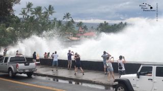 Incoming waves tower over bystanders in Kona, Hawaii, U.S. August 23, 2018 Credit: Ryan Leinback
