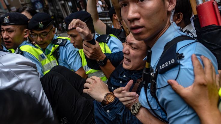 Police remove a protester from outside of the Foreign Correspondents Club  in Hong Kong