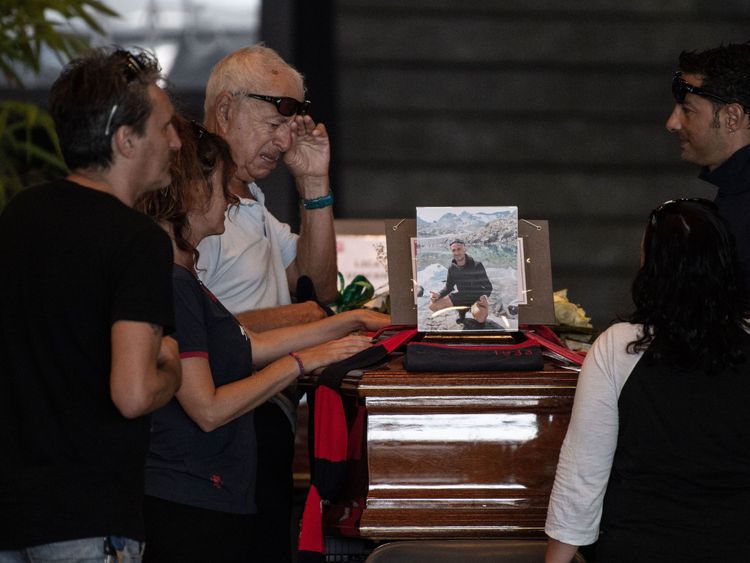 Relatives pray and pay their respects near the coffin of a victim of the Morandi bridge&#39;s collapse, in Genoa, on August 17, 2018. - Italy prepares to pay homage to the victims of the deadly bridge collapse as rescuers use diggers to claw through mountains of rubble in a desperate search for survivors, but some families are reportedly refusing the join the state memorial ceremony. A vast span of the Morandi bridge caved in during a heavy rainstorm in the northern port city of Genoa on August 14, 
