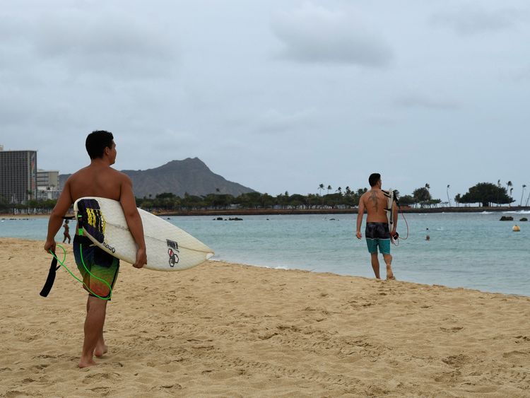 Surfers walk to the water to paddle out as Hurricane Lane approaches Honolulu, Hawaii, U.S. August 23, 2018. REUTERS/Hugh Gentry