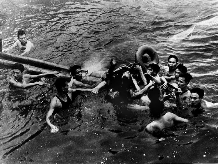 John McCain (C) being pulled from a lake in Hanoi after his Navy warplane was downed