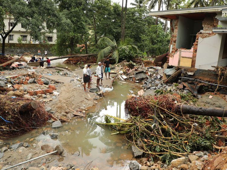 Indian residents look at houses destroyed by flood waters at Kannappankundu in Kozhikode, in the Indian state of Kerala 
