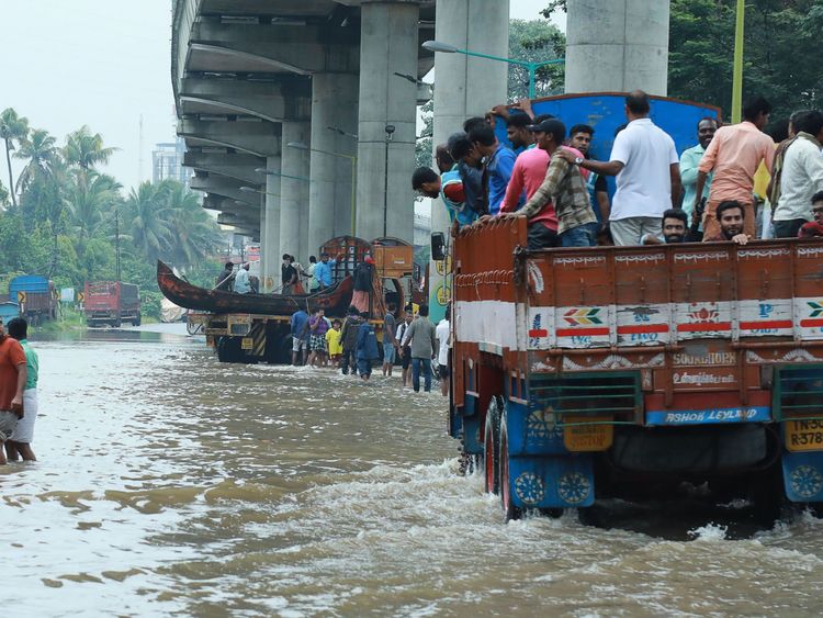 Indian commuters travel in a truck to a safer place as flood waters ravaged the National Highway 47 in Ernakulam district of Kochi, in the Indian state of Kerala