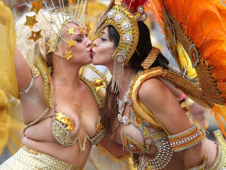 Performers in costume kiss as they take part in the carnival on the main Parade day of the Notting Hill Carnival in west London on August 27, 2018. - Nearly one million people are expected by the organizers Sunday and Monday in the streets of west London's Notting Hill to celebrate Caribbean culture at a carnival considered the largest street demonstration in Europe. (Photo by Daniel LEAL-OLIVAS / AFP) (Photo credit should read DANIEL LEAL-OLIVAS/AFP/Getty Images)