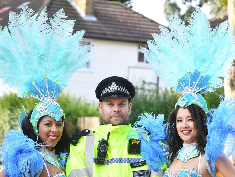 Dancers pose with a police officer as they prepare to take part in the Notting Hill Carnival in west London. PRESS ASSOCIATION Photo. Picture date: Monday August 27, 2018.  Photo credit should read: John Stillwell/PA Wire