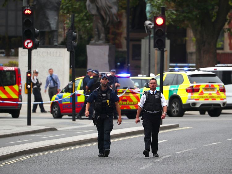 Police patrol the scene outside parliament where a car is said to have crashed