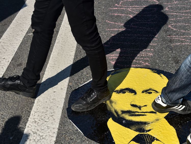 Protesters step on a sticker of Vladimir Putin during a rally against the government&#39;s proposed pension reform 